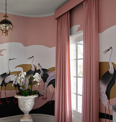 Colorful curtains made of Holland & Sherry Andes in Blush match walls painted with a sunset scene with sandhill cranes
