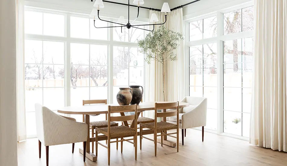 A bright dining room with tall windows in the Studio McGee home features Tailored Pleat Drapery in Luxe Linen, Oyster