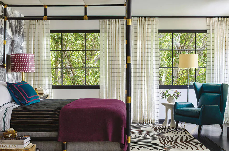 A boho-inspired bedroom with jewel tones and different patterns features curtain sheers made of Sahara Stripe in Onyx