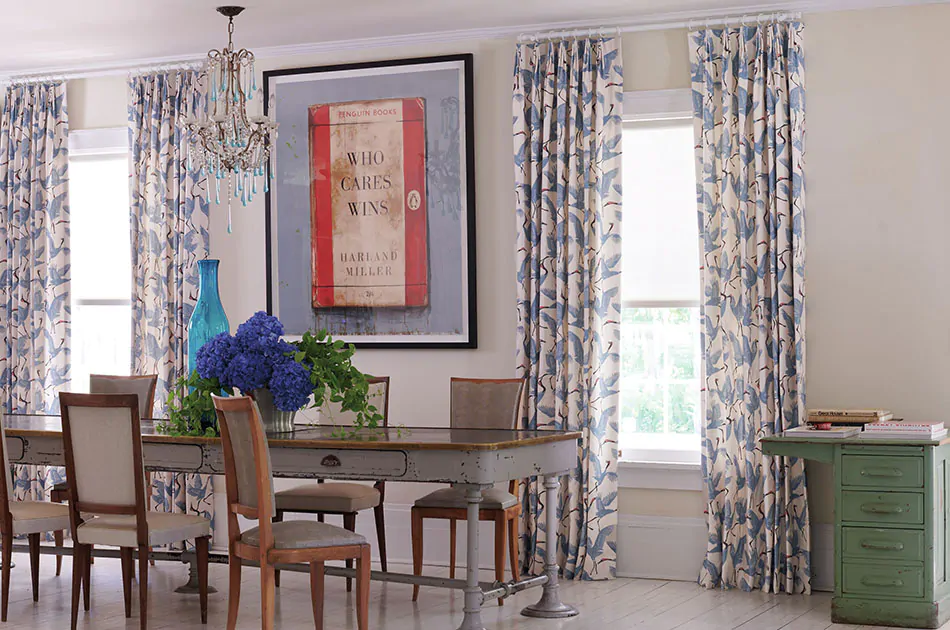 Colorful curtains made of Family of Cranes in Waverly Blue adds movement and color to a rustic, eclectic dining room