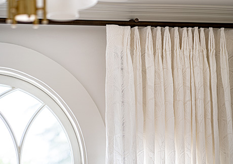 Tailored Pleat Drapery made of Feather Palm Embroidery in Lace delivers a delicate look to a room with an arched window