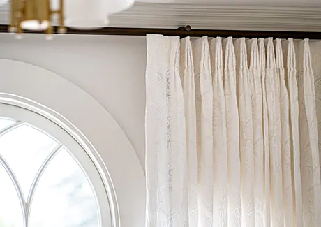 Tailored Pleat Drapery made of Feather Palm Embroidery in Lace delivers a delicate look to a room with an arched window