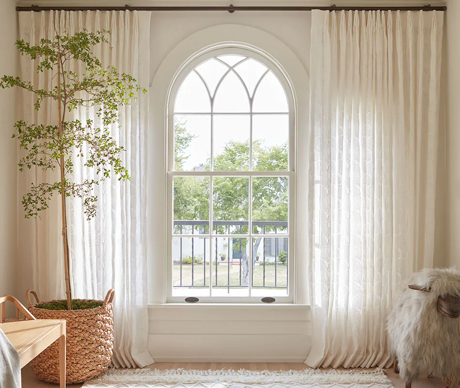 Sheer nursery curtains made of Feather Palm Embroidery in Vintage Lace soften the light in a bright nursery