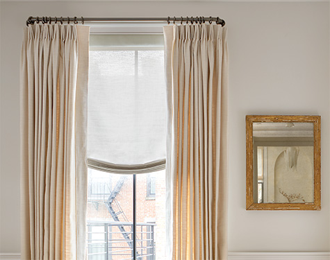 A tall window features Tailored Pleat Drapery made from Sunbrella Alma in Beige for a warm inviting look