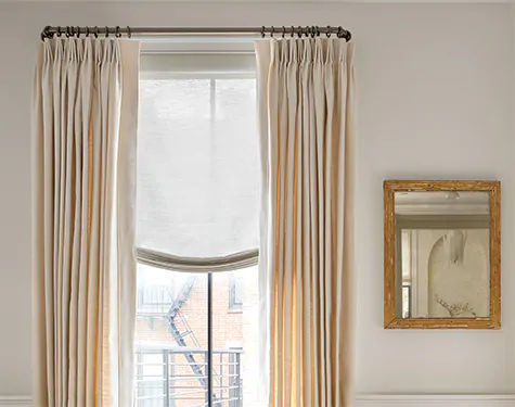 A tall window features Tailored Pleat Drapery made from Sunbrella Alma in Beige for a warm inviting look