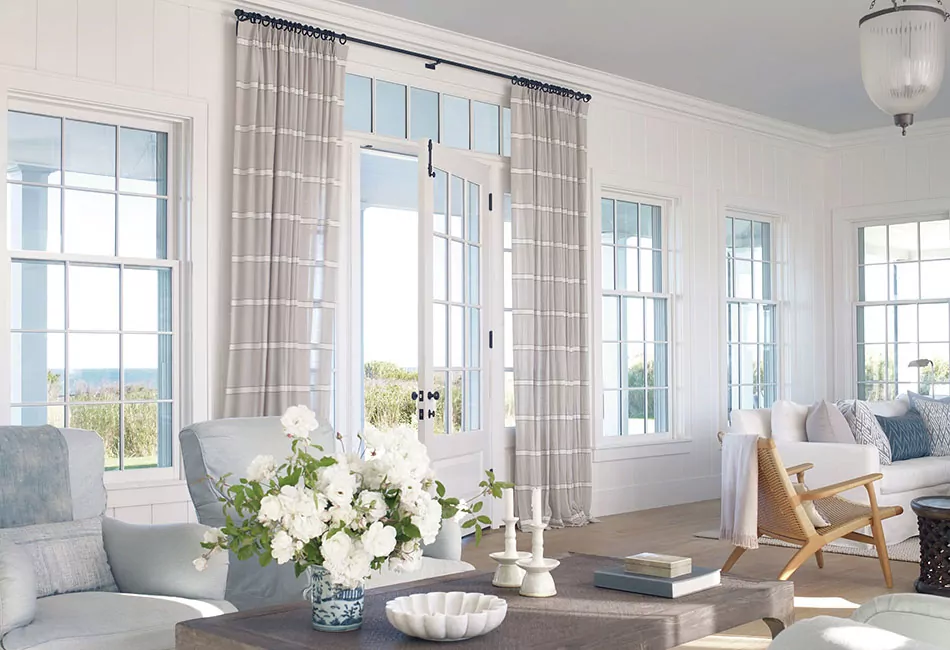 An example of living room curtain ideas is a bright coastal-inspired space with stripes drapes