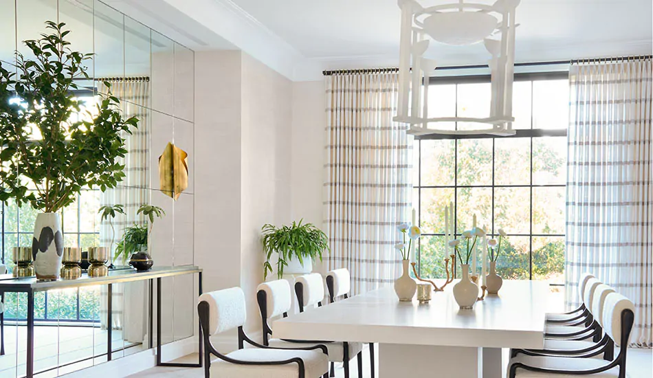 A dining room shows modern curtain ideas in its Tailored Pleat Drapery made of neutral Harbor Stripe in Stone