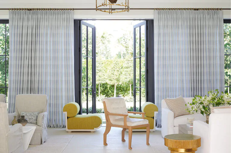 A bright room with glass doors has Tailored Pleat Drapery of Jasmine, Sky, showing when to choose curtains or no curtains
