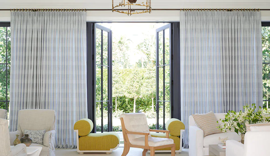 Drapery panels of Tailored Pleat Drapery in Victoria Hagan's Jasmine in Sky contrast warm-toned furniture