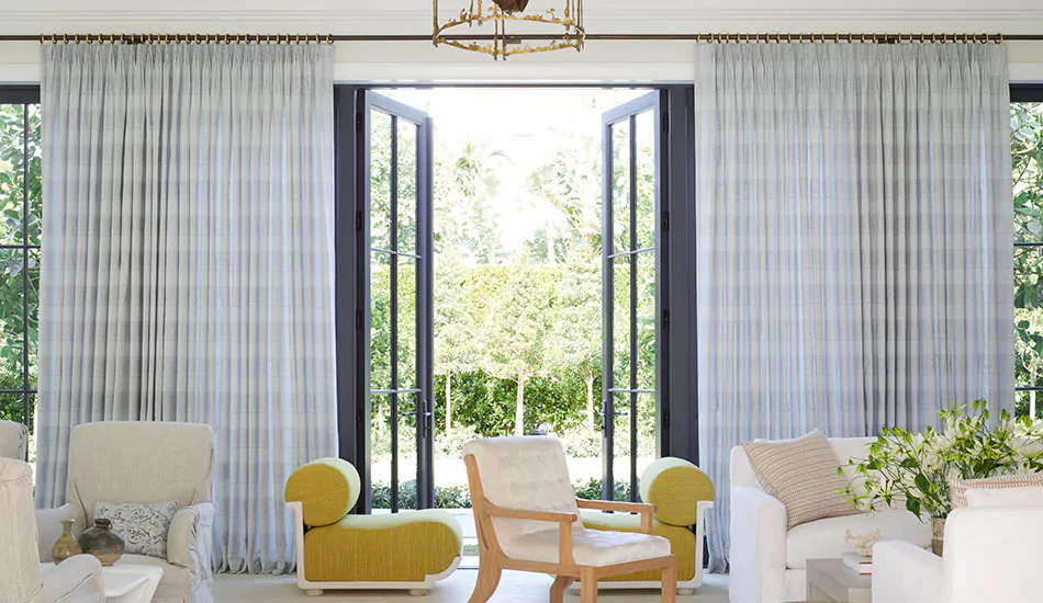 Tailored Pleat Drapery made of Jasmine in Sky in a sunny conservatory could be called drapes vs curtains but both can be used
