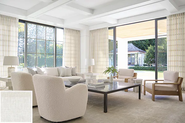 Colorful curtains made of Lily in Buff feature east-west stripes that add subtle visual interest to a warm-toned living room