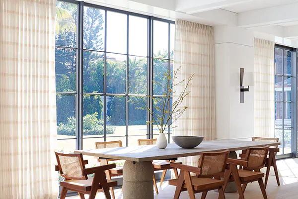 Between curtains or no curtains, a contemporary dining room chose Tailored Pleat Drapery of Lily in Buff for visual interest