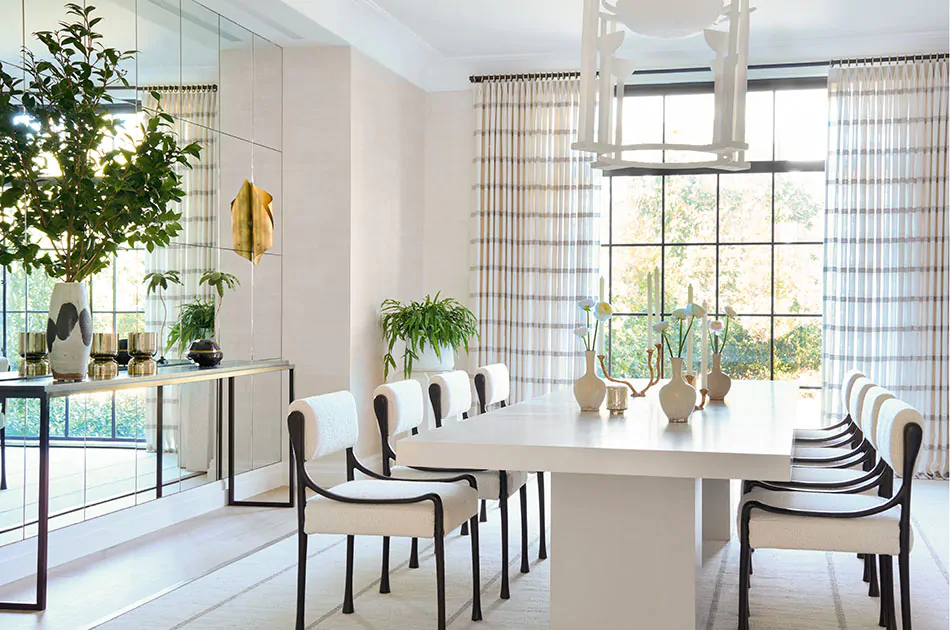 Tailored pleat drapes are pulled to the side, letting light into a mid-century modern styled dining room