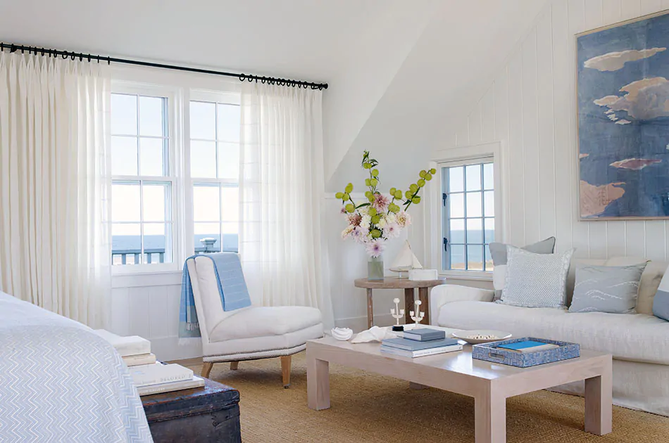 Coastal window treatments include Tailored Pleat Drapery made of Sankaty Stripe in Moon in a white room with blue accents