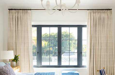 A bedroom features highly hung Tailored Pleat Drapery in Tidal Line, Sand, showcasing one of Nathan's window treatment tips