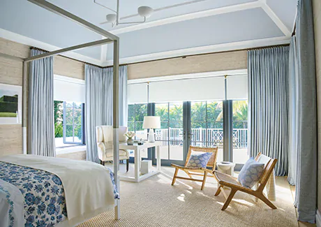 Tailored Pleat Drapery made of Vanda in Sky matches the ceiling and contrasts the beige textured wallpaper in a large bedroom