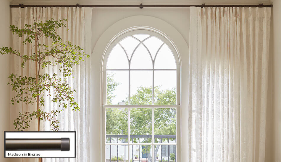 One of the window treatment trends 2024 seen here is having bold drapery hardware that draws the eye to the window