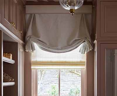Tulip linen Roman Shades made of Luxe Linen in Oyster cover a window in a luxe walk-in closet with mauve painted walls