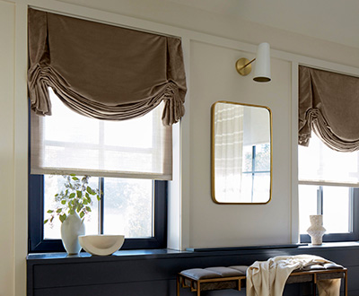 Roman shades for windows include Tulip Roman Shades made of Velvet in Camel in an elegant living room