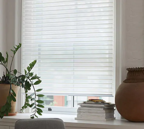 UV shades in the Venetian Roller Shade style made of Seaside in White feature tiltable vanes between two layers of sheers