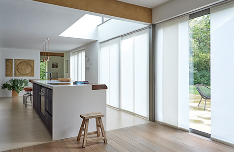 Window coverings in an open concept kitchen include Vertical Blinds made of Park Window to cover the wall-to-wall windows
