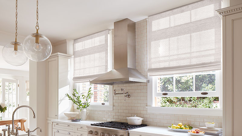 A bright modern kitchen features tall windows with woven shades made of Artisan Weaves Monterey in White