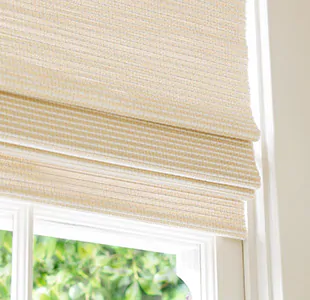 A close up of a Woven Wood Shade made of Somerset in Cloud with privacy lining shows some light filtering through