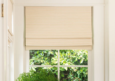 One of the window treatment trends 2024 is the use of artisan weaves seen on these Woven Wood Shades in a dining room
