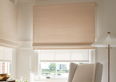 A Waterfall Woven Wood Shade made of Artisan Weaves Somerset in Cloud is outside mounted on a tall window