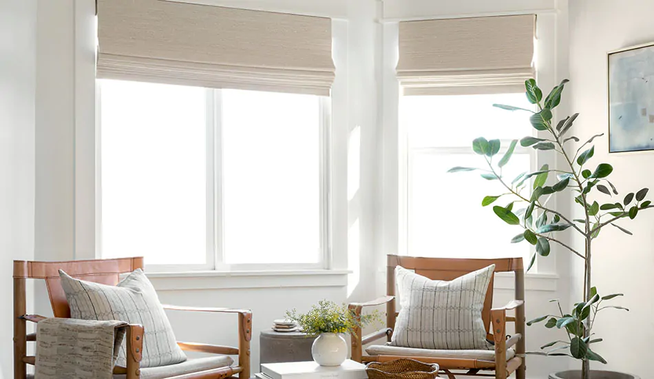A sitting area with warm, neutral colors features studio mcgee window treatments of Woven Wood Shades