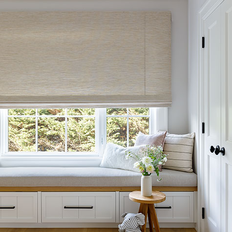 Window shades in a boho bedroom include Waterfall Woven Wood Shades made of Grassweave in Hemp for an organic look