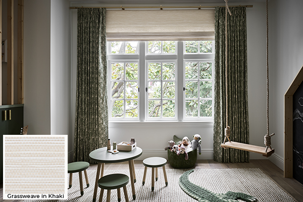 Kids curtains in a playroom feature a leafy pattern for a jungle theme and are paired with Woven Wood Shades for texture
