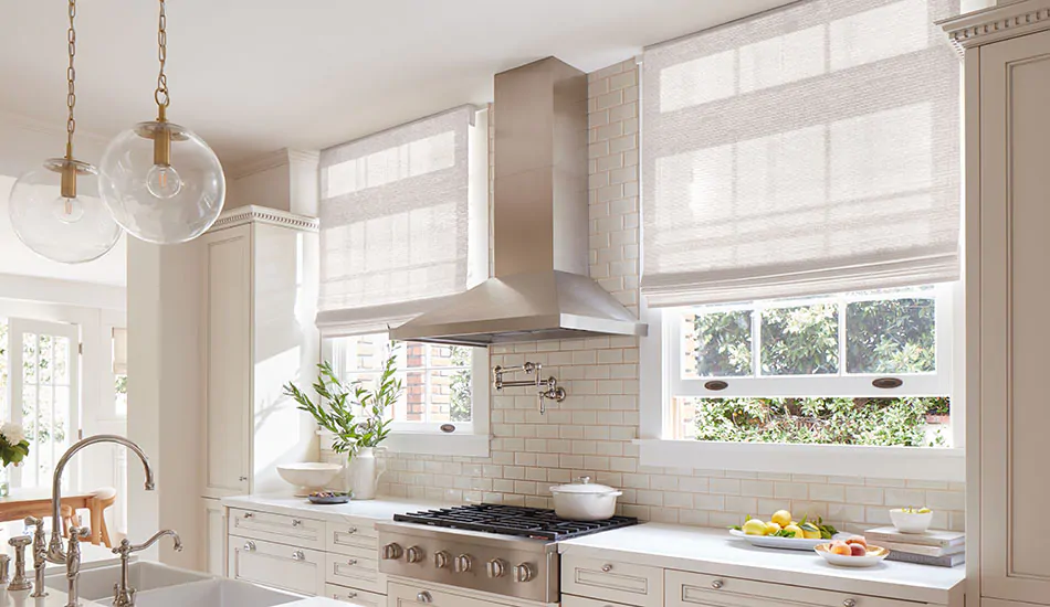 A warm white kitchen features outside mount Waterfall Woven Wood Shades made of Artisan Weaves Monterey in White