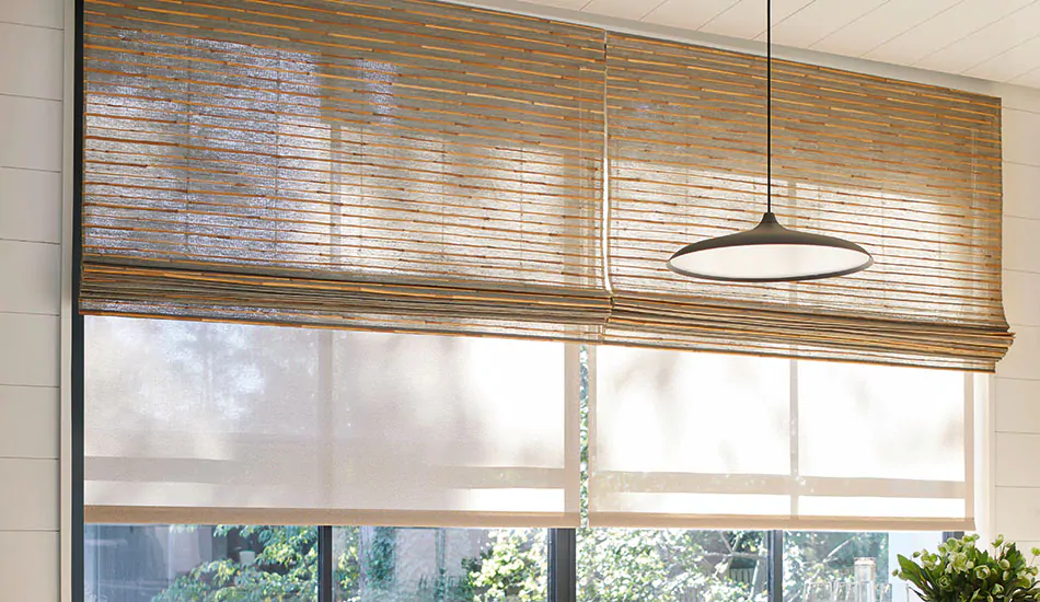 A boho-inspired dining room with a wood dining set features woven window shades made from Reed material in Slate