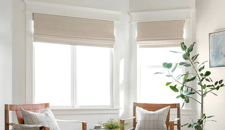 Woven Wood Shades made of Bayshore in Parchment adorn a bay window in a sitting room in place of blinds for bay windows