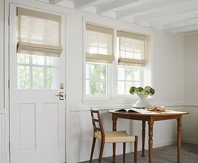 A door window shade is made of a Waterfall Woven Wood Shade in Grassweave, Hemp, and it covers the glass part of a door