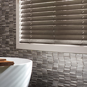 Wood Blinds made of 2-inch Bamboo in Black cover a window in a modern tranquil bathroom with black tile