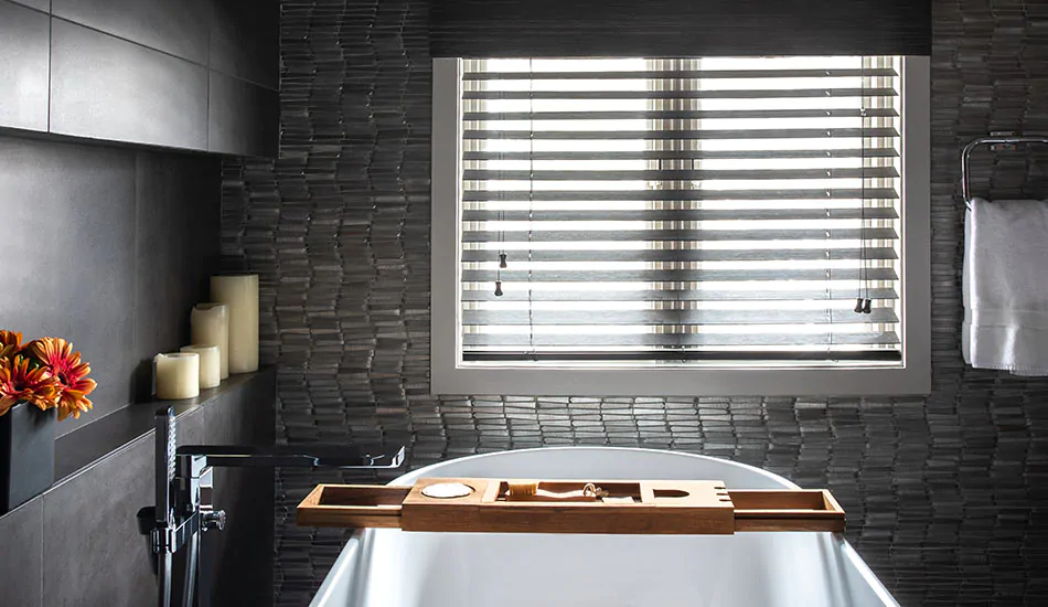A dark bathroom has Wood Blinds made of Bamboo in Black with a linear look that shows the difference between blinds vs shades