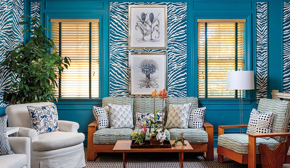 A bright turquoise-painted room has Wood Blinds made of Bamboo in Natural that bring a warm natural wood tone to the space