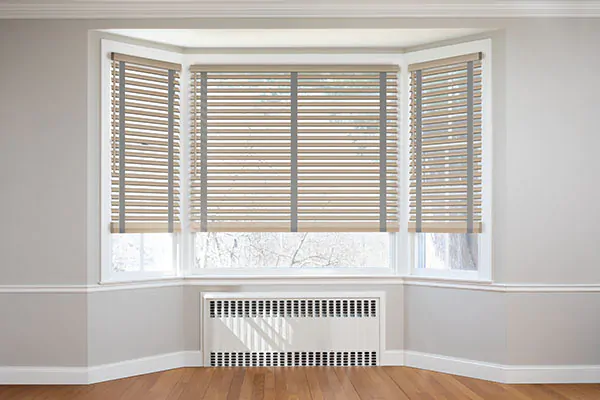 A simple bay window features Wood Blinds made of 2-inch Basic Bamboo in White for a simple, attractive look
