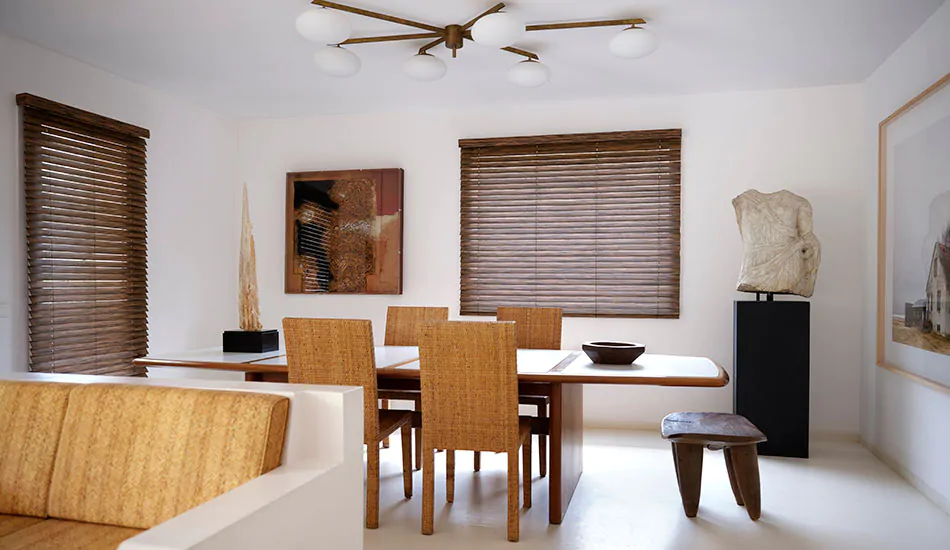 A mid-century modern dining room features Wood Blinds and valance made of 2-inch Exotic Ebony for a striking look