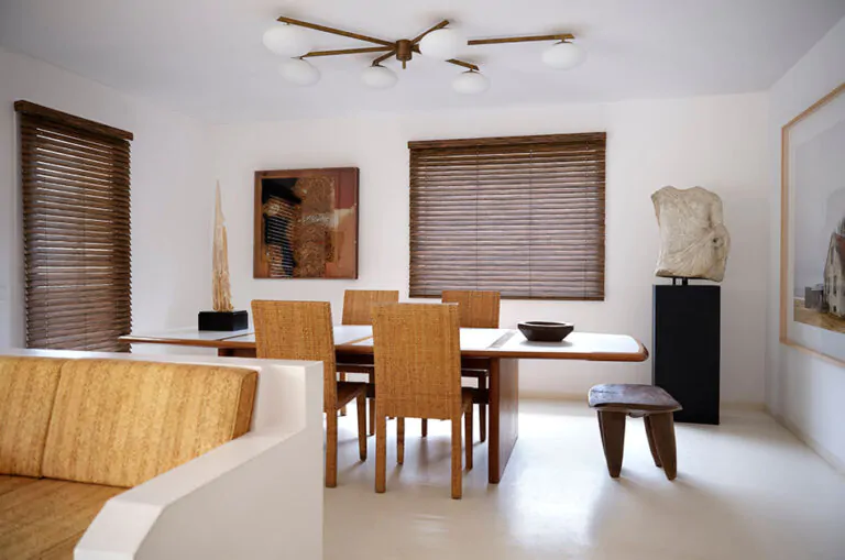 A modern dining room has 2-inch Wood Blinds made of Exotic Ebony that covers the window showing how to put blinds down