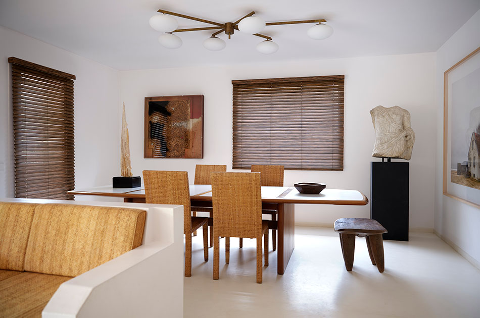 A modern dining room has 2-inch Wood Blinds made of Exotic Ebony that covers the window showing how to put blinds down