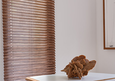 Types of blinds include Wood Blinds made of 2-inch Exotic in Ebony over a tall window in a mid-century modern dining room