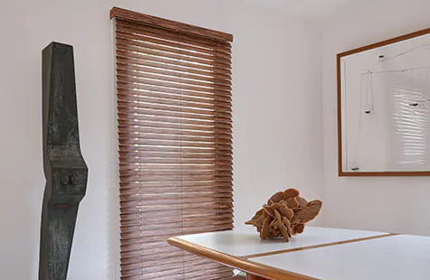 Wood Blinds made of 2-inch Exotic in Zebrano is used as window treatments for large windows on a tall dining room window