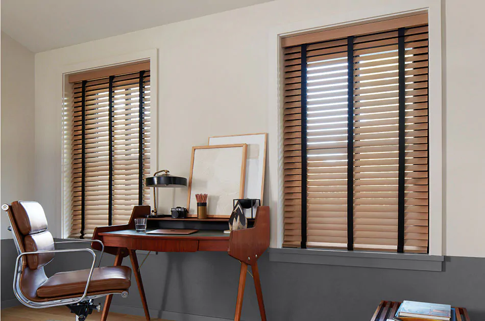 An office features inside mount wood blinds with black tape showing why you would choose inside vs outside mount blinds