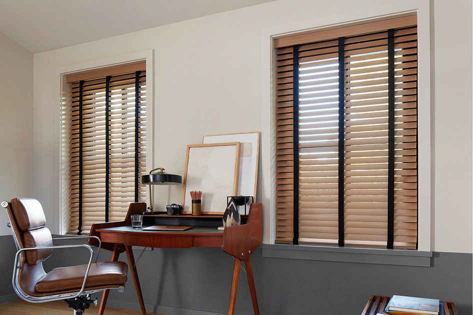 Mid century modern (MCM) blinds in a warm wood tone with black decorative tape in a sunlit home office