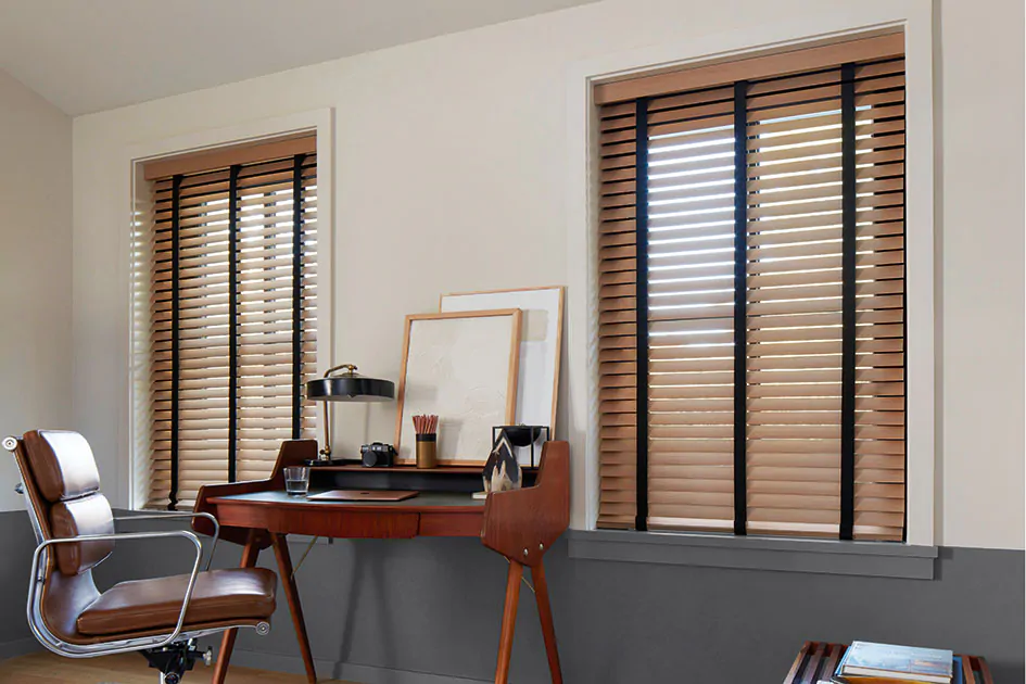 A mid century modern office features wood blinds with an inviting warm color and black decorative tape