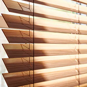 A close up Wood Blinds slats made of 2-inch Exotic wood in Zebrano show how to tilt the slats for bathroom window privacy