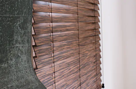 Wood blinds made with exotic wood in an intricate Zebrano finish are a refined choice for bay window blinds